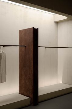 an open closet with clothes hanging on the line and two white shirts hung to dry