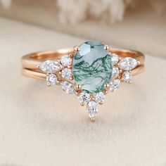 a ring with a green stone surrounded by white and clear stones on top of it