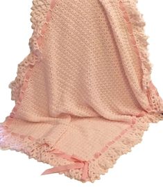 a pink crocheted blanket with ruffled edges