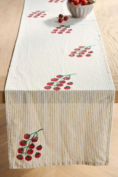 a striped table runner with cherries on it