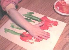 a child's hand on a piece of paper that has been painted red and green