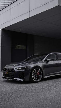 a grey car parked in front of a building