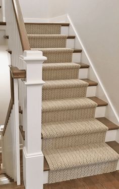 a staircase with carpeted steps and white banisters