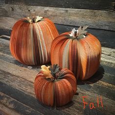 three pumpkins sitting on top of a wooden bench