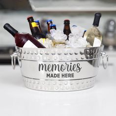 a metal bucket filled with bottles of wine and ice on top of a white counter