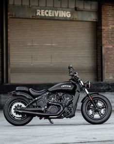 a black motorcycle parked in front of a building