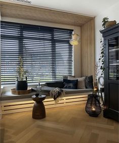 a living room filled with furniture and windows covered in wooden slatted blindes