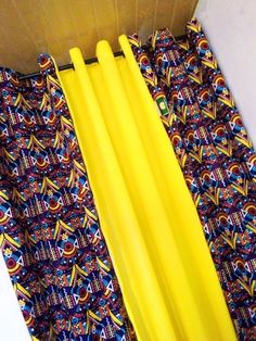 a pair of yellow umbrellas sitting on top of a colorful cloth covered shower curtain