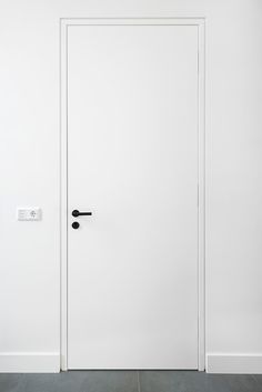 a white door with two black handles in a room