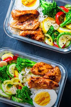 two plastic containers filled with chicken, vegetables and hard boiled eggs on top of rice