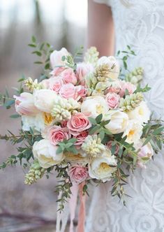 a bridal holding a bouquet of pink and white flowers