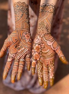 two hands with henna tattoos on them