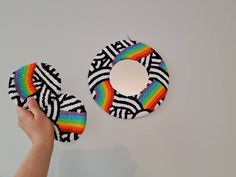 someone is holding two pieces of yarn in front of a mirror that has been made to look like a rainbow ring