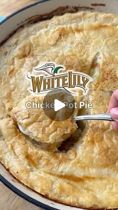 a person is spooning something out of a pie in a pan with the words white lily chicken pot pie on it