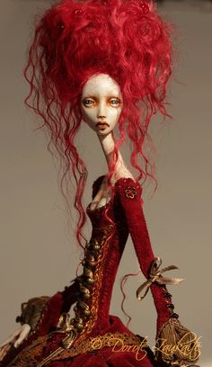 a doll with red hair sitting on top of a table