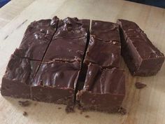 pieces of chocolate cake sitting on top of a wooden cutting board