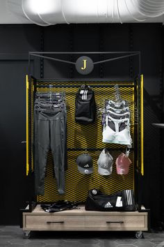 a display case with clothes and sports equipment on the shelves in front of it, along with other items