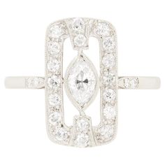 This striking Art Deco Diamond Cluster Ring showcases a 0.40 carat old marquise cut diamond at it’s centre. Rub over set, the diamond boasts a colour of F and clarity of VS1. Surrounding the centre stone is a rectangular halo of eight cut diamonds, totalling 0.38 carats. These surrounding diamonds match the centre in quality. Crafted entirely in platinum, this ring embodies the classic geometrical design and elegance that define the Art Deco era. Gemstone: Diamond Stone Shape: Marquise Cut Carat Weight: 0.40 Colour: F Clarity: VS1 Metal: Platinum Age: 1920s Size: M Shopping Photography, Marquise Cut Diamond, Modern Art Deco, Art Deco Diamond, Art Deco Era, Diamond Cluster Ring, Marquise Cut, Love Ring, Gold Jewelry Fashion