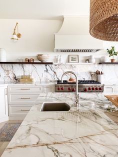 a kitchen with marble counter tops and an island in front of the stove top oven