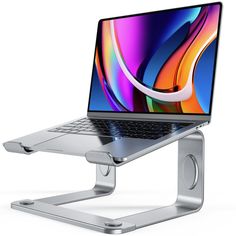 an open laptop computer sitting on top of a metal stand