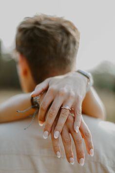 a close up of two people holding each other with their hands on top of one another