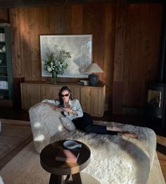 a woman laying on top of a white couch in a living room