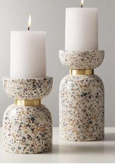 two white candles sitting next to each other