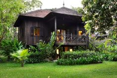 a wooden house surrounded by lush green trees