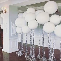 some white balloons are hanging from the ceiling