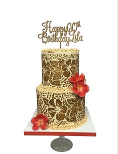 a three tiered cake with red flowers on the top is decorated in gold and brown