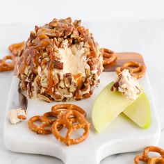 an apple and some pretzels on a white plate