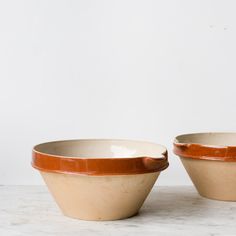 two brown and white bowls sitting on top of a table