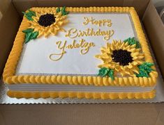 a birthday cake with sunflowers on it in a box