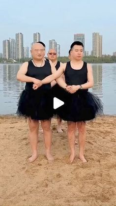 three people standing on the beach with their arms around each other's waists