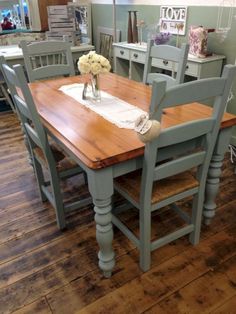 a dining room table with chairs and an umbrella over it in the middle of a store