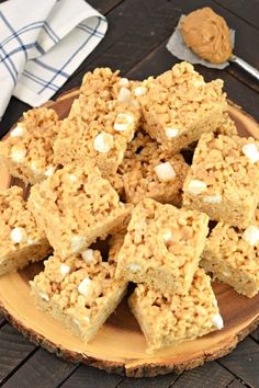 a plate full of rice krispy treats on top of a wooden table next to a fork