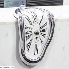 a clock that is sitting on the side of a wall with roman numerals