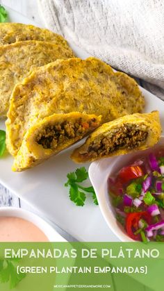 an enchilada is cut in half on a plate with salsa and guacamole