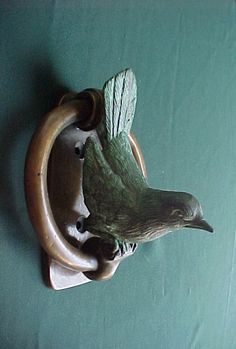 a bird is perched on the handle of a doorknob that has been made out of wood