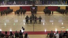 a group of people standing on top of a basketball court