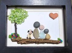 a shadow frame with some rocks and a tree on it that is made to look like two people sitting next to each other