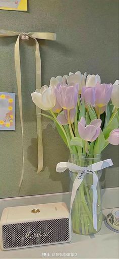 a vase filled with flowers next to an air conditioner