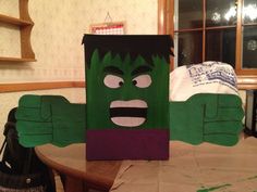 a cardboard cut out of the hulk face on top of a table with a handbag