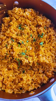 a pan filled with rice and vegetables on top of a table