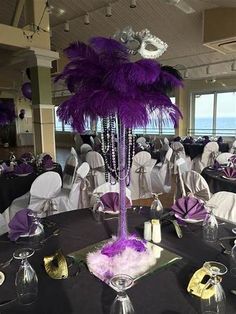 a room filled with tables covered in purple and white decorations