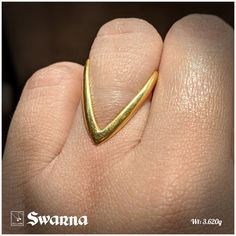 a person's hand with a gold ring on it