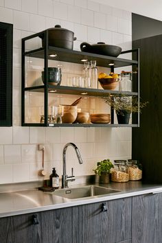 a kitchen sink and shelves filled with dishes