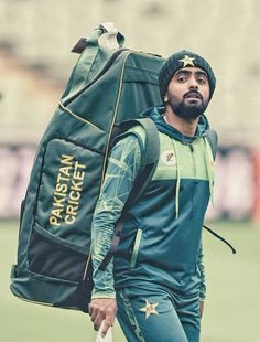 a man carrying a large bag on top of a field