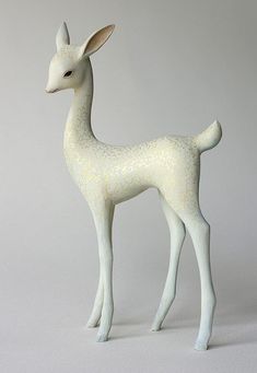 a small white deer figurine on a gray background