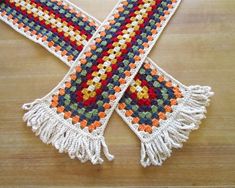 two crocheted scarfs on a wooden table